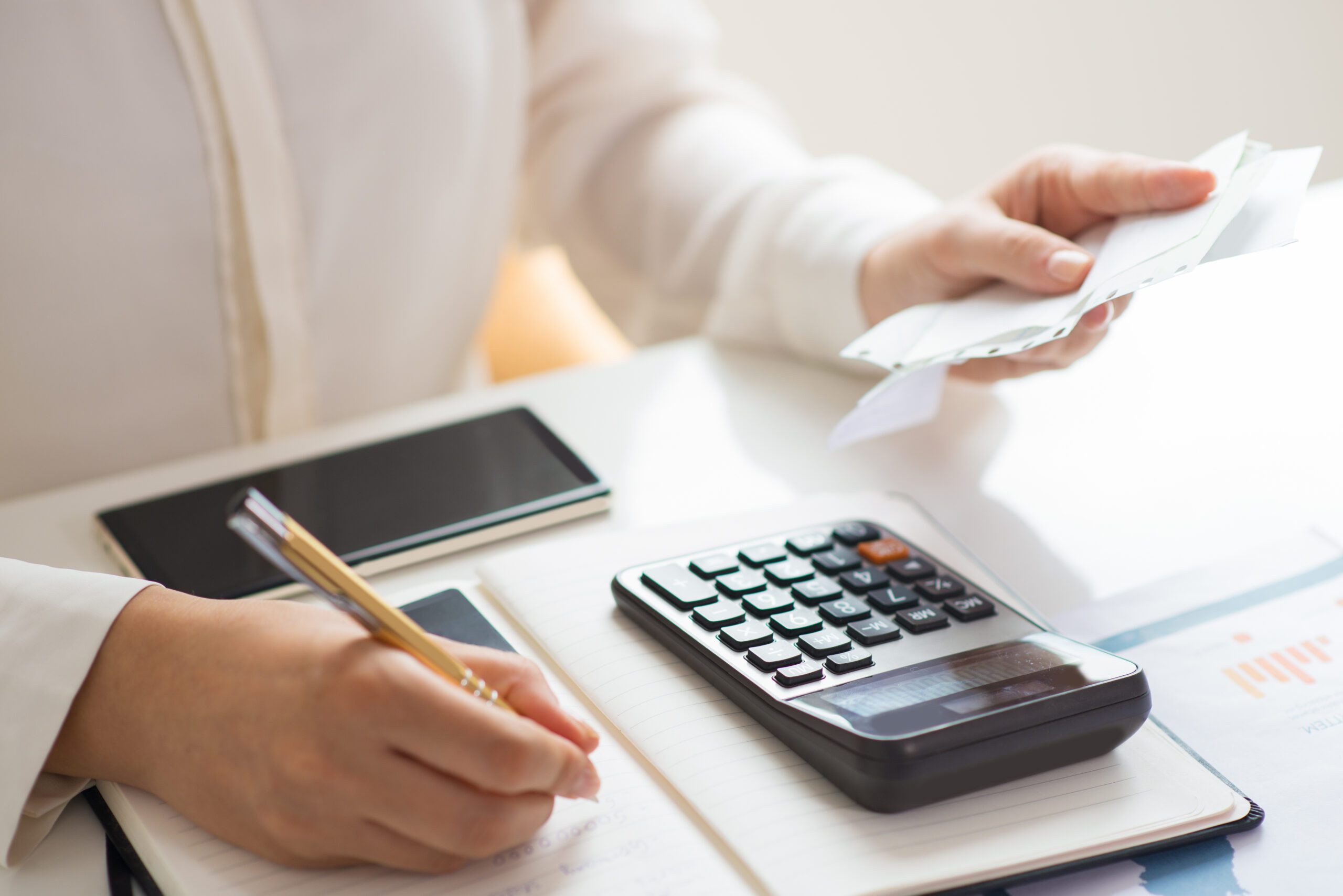 closeup person holding bills calculating them scaled