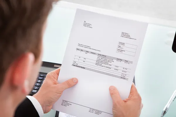 depositphotos 29295885 stock photo businessman holding invoice paper