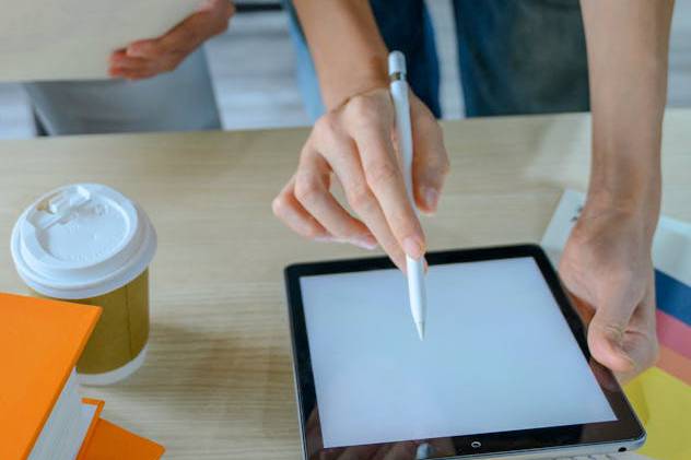 person holding tablet and pen working in the office